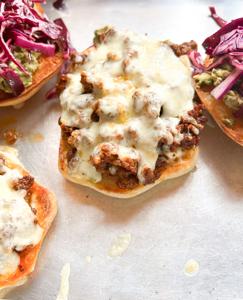 open faced sandwiches with melted cheese on top of chorizo 