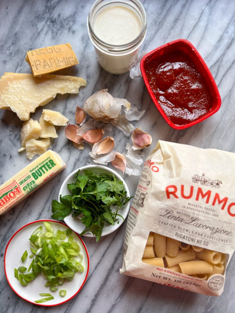 ingredients to make gochujang pasta: parmesan cheese, garlic, gochujang, heavy cream, parsley, butter, scallions, rigatoni 