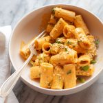 bowl filled with rigatoni pasta in gochujang pasta with fork