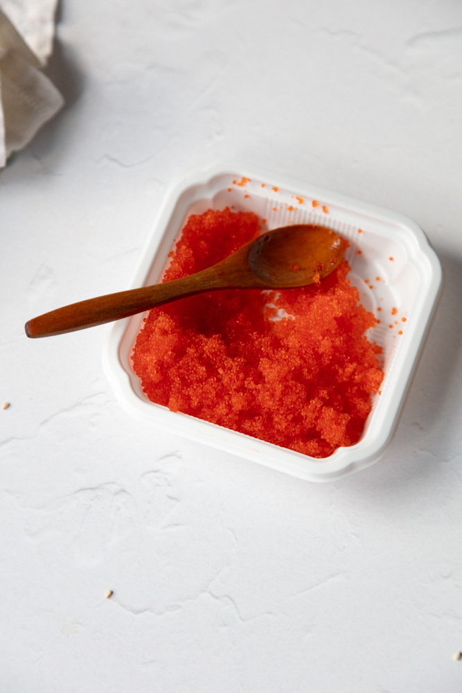 Bright orange tobiko (flying fish roe) in a small white dish