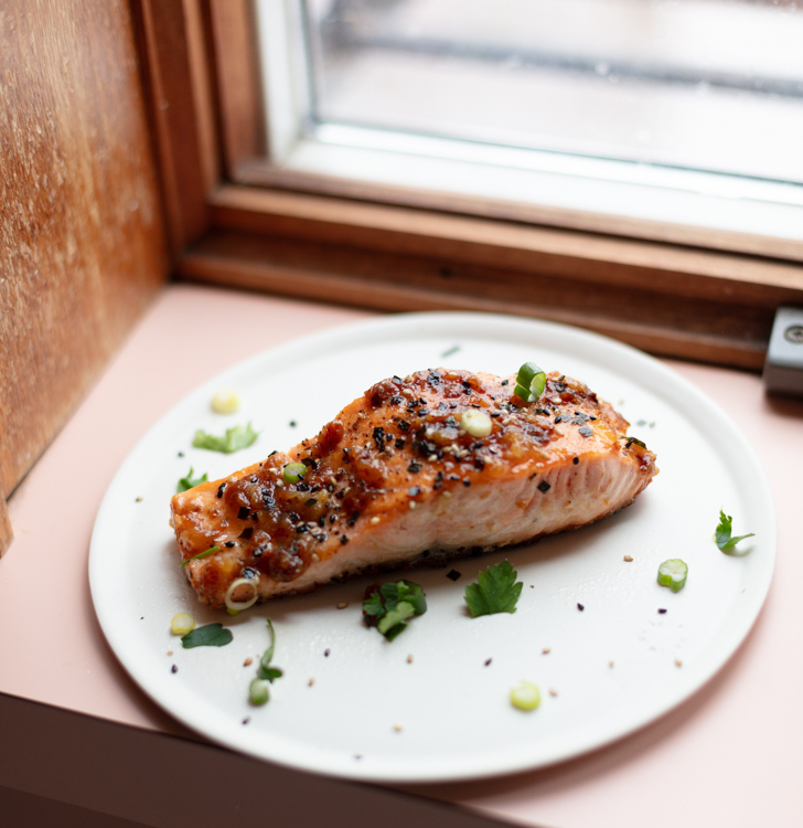 miso butter salmon filet on a plate near a window