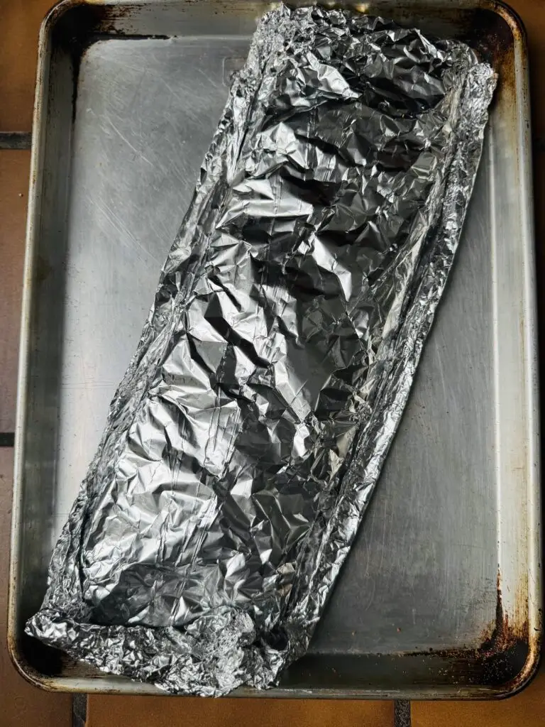St. Louis ribs in foil on a baking sheet