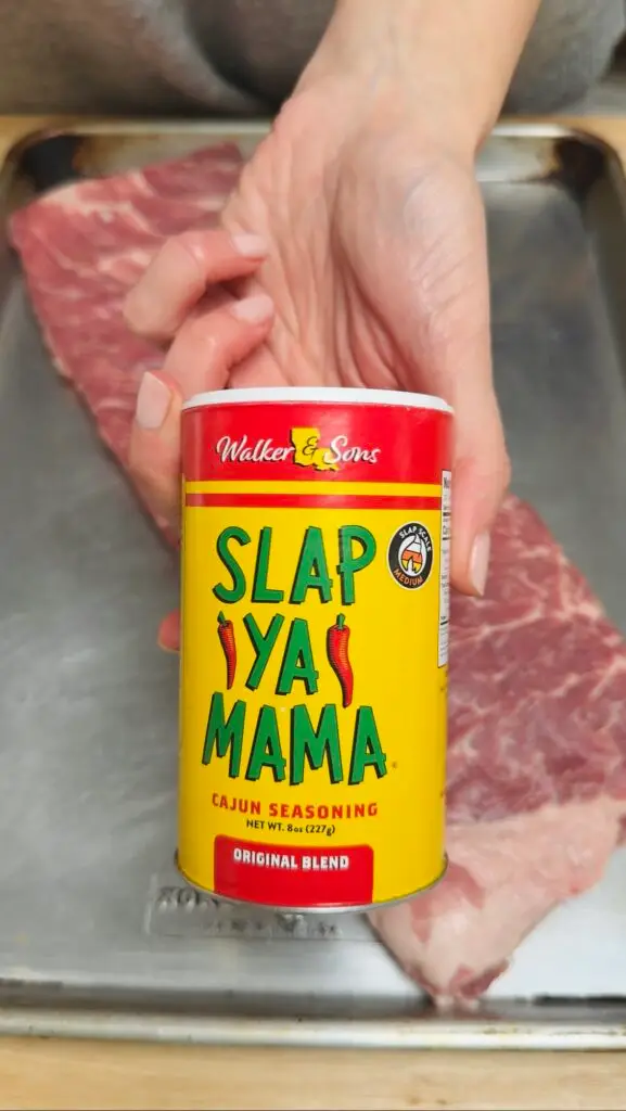 rack of st louis style ribs with slap yo mama seasoning shaker