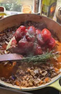 tomatoes, fresh herbs, over sauteed veggies in pan