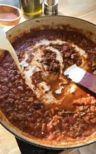 heavy cream poured into meat sauce