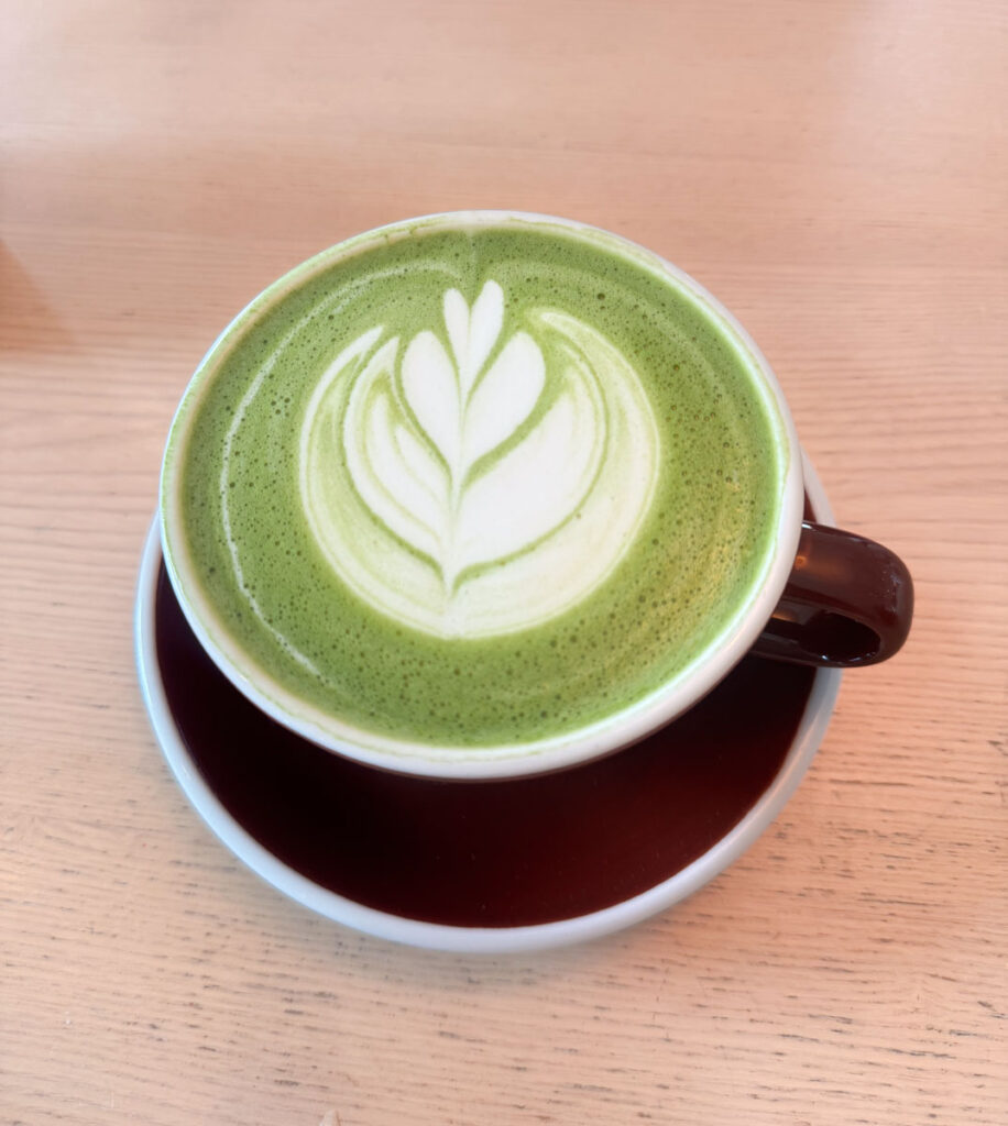 Hot dirty matcha latte with latte art in a ceramic mug.