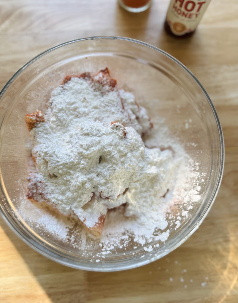 Coating ingredients added on top of the raw chicken wings in a mixing bowl.