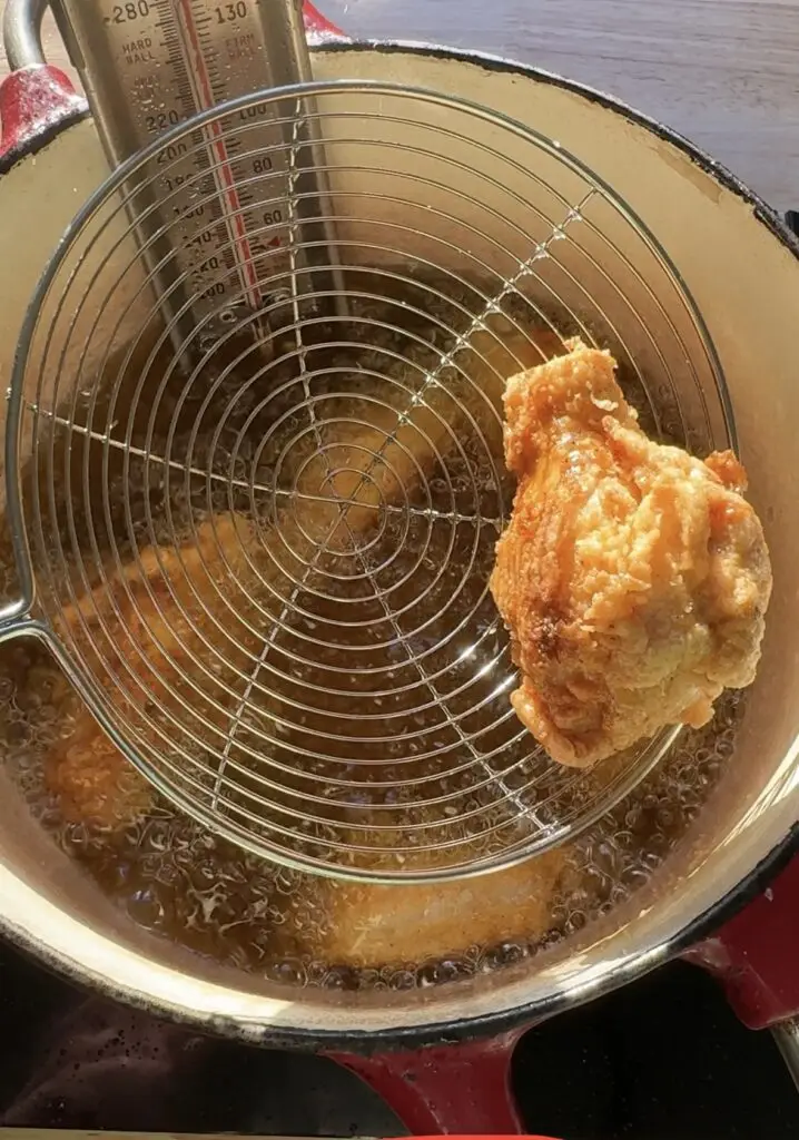 Taking a crispy chicken wing from hot oil.