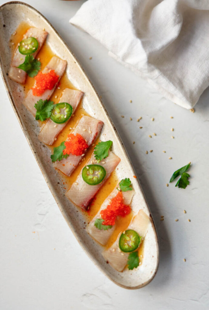 Yellowtail hamachi crudo topped with tobiko, jalape&ntilde;o, and cilantro in ponzu sauce