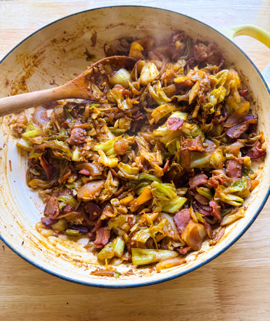 sauteed cabbage with bacon cooked in a skillet with caramelized onions and garlic