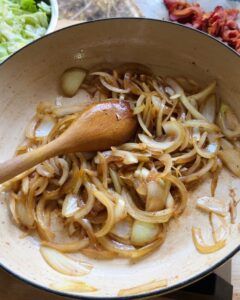sliced onions sautéing in skillet for easy sauteed cabbage recipe