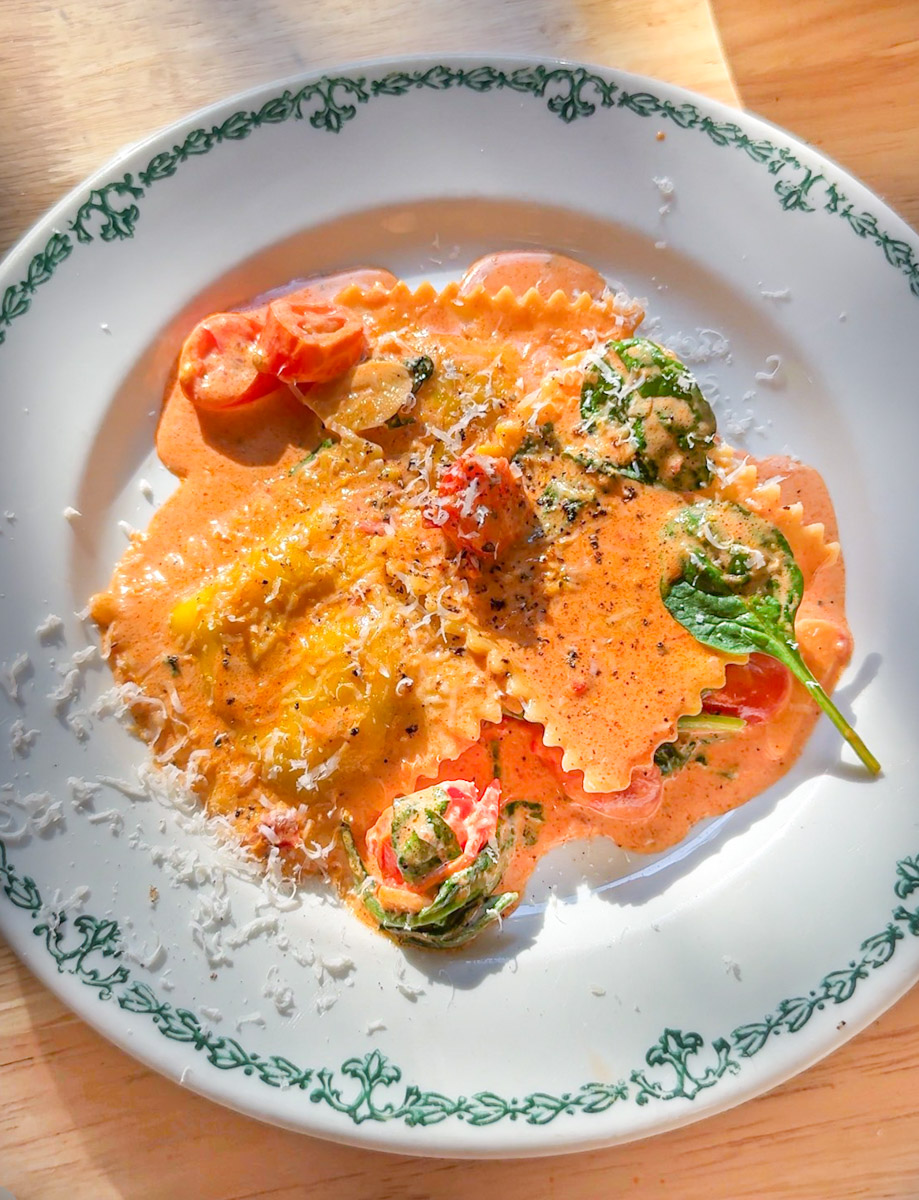 lobster ravioli with creamy tomato basil sauce on white plate