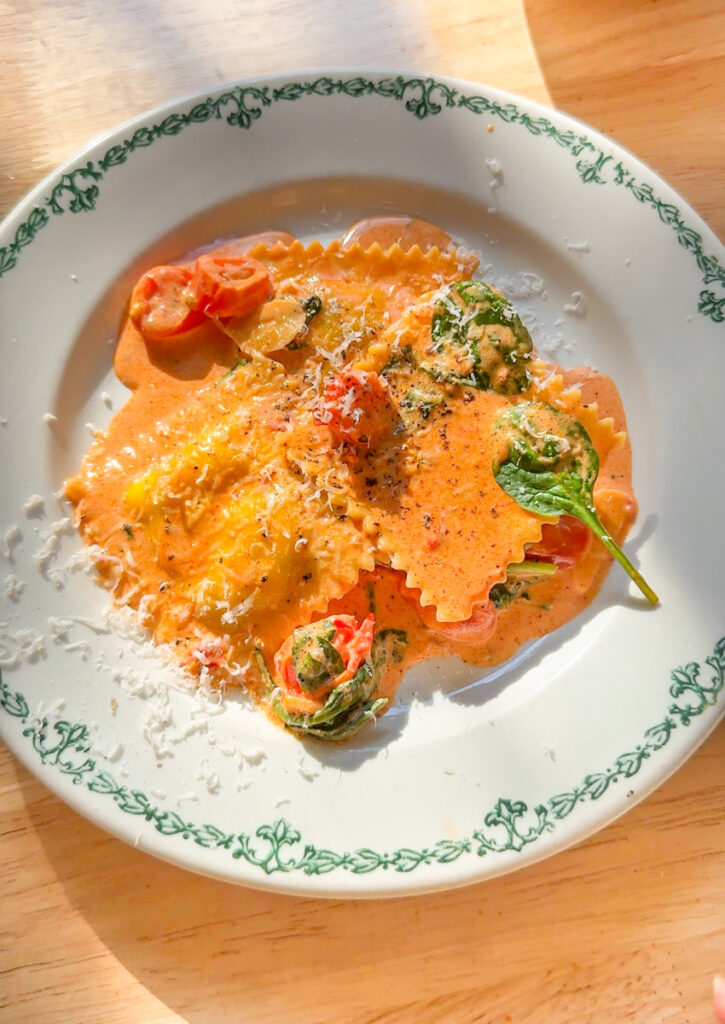 lobster ravioli with creamy tomato basil sauce on white plate