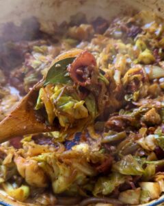 close-up of sauteed cabbage with bacon and onions cooking in a skillet, tender caramelized cabbage with crispy bacon for an easy side dish