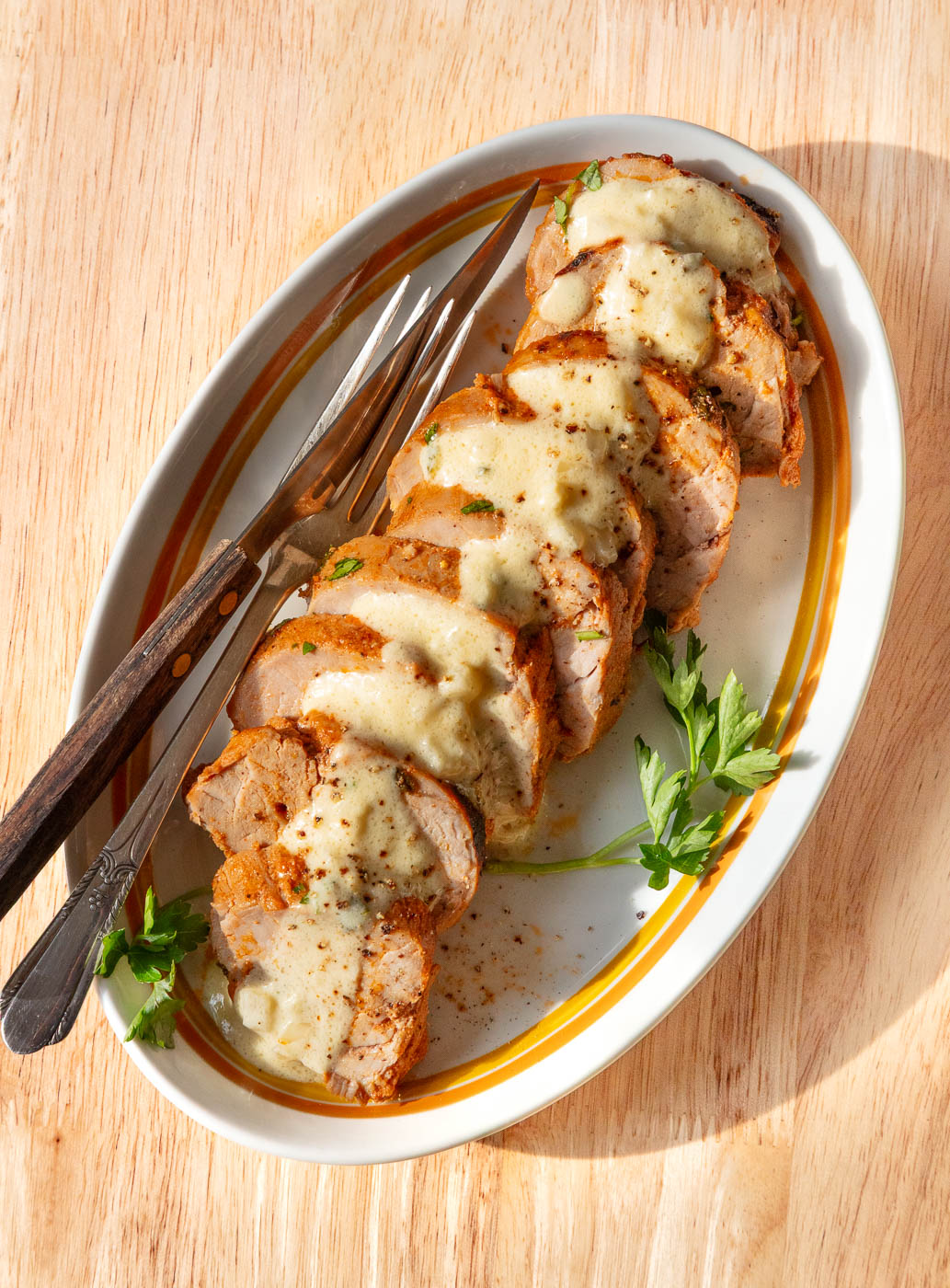 Sliced baked pork tenderloin on a serving platter.