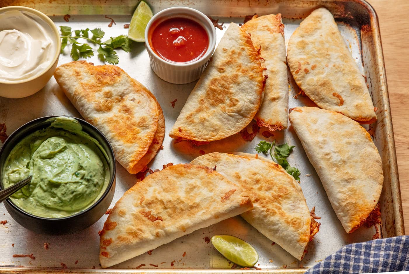 crispy baked chicken tacos on a sheet pan served with avocado crema and salsa