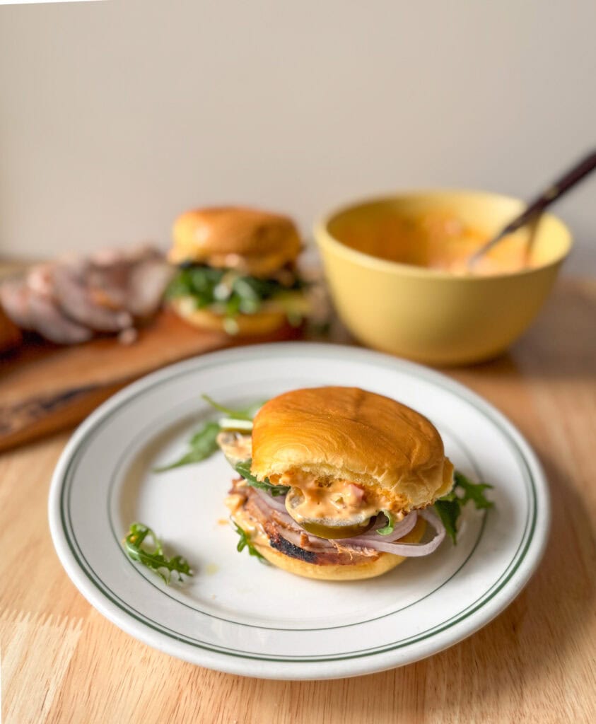 pork tenderloin slider with Calabrian chili mayo, arugula, pickled jalape&ntilde;os, and shallots on a toasted bun