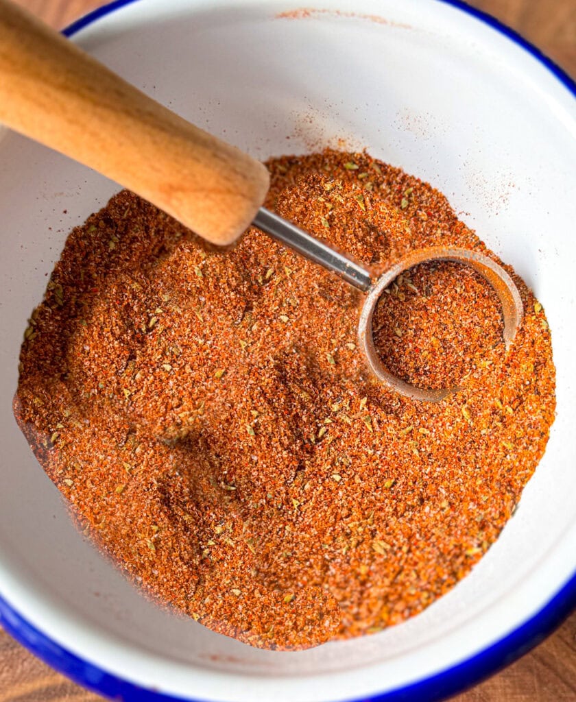 homemade chicken taco seasoning being scooped from a bowl with measuring spoon