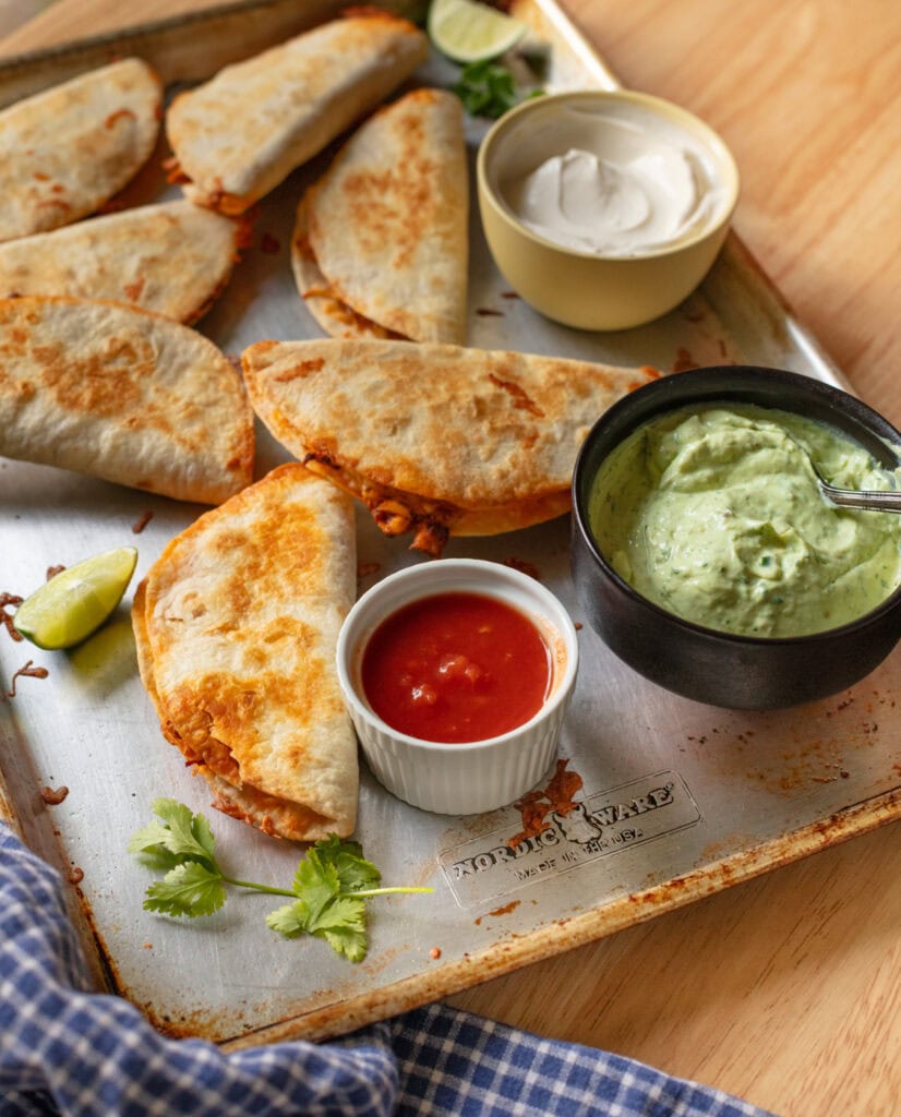 crispy baked chicken tacos on sheet pan with avocado crema and salsa
