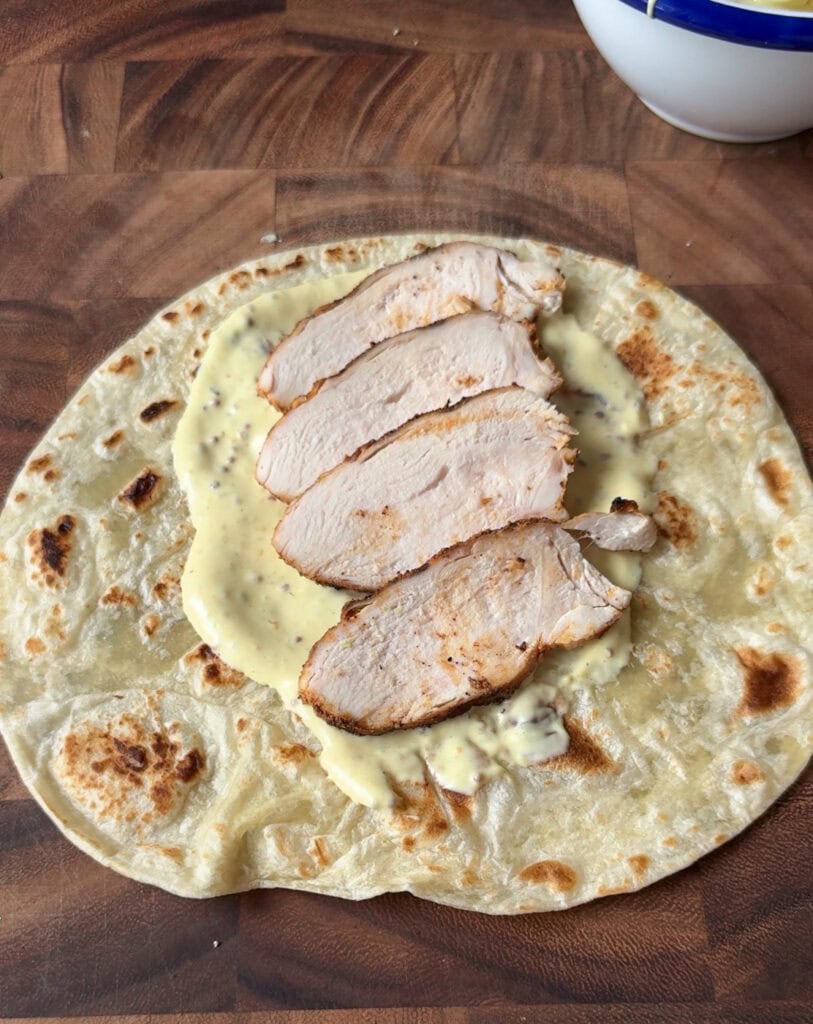 sliced grilled chicken on tortilla
