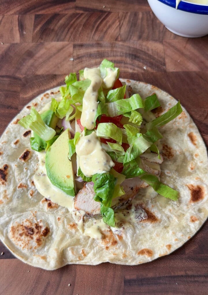 grilled chicken and vegetables on open flour tortilla