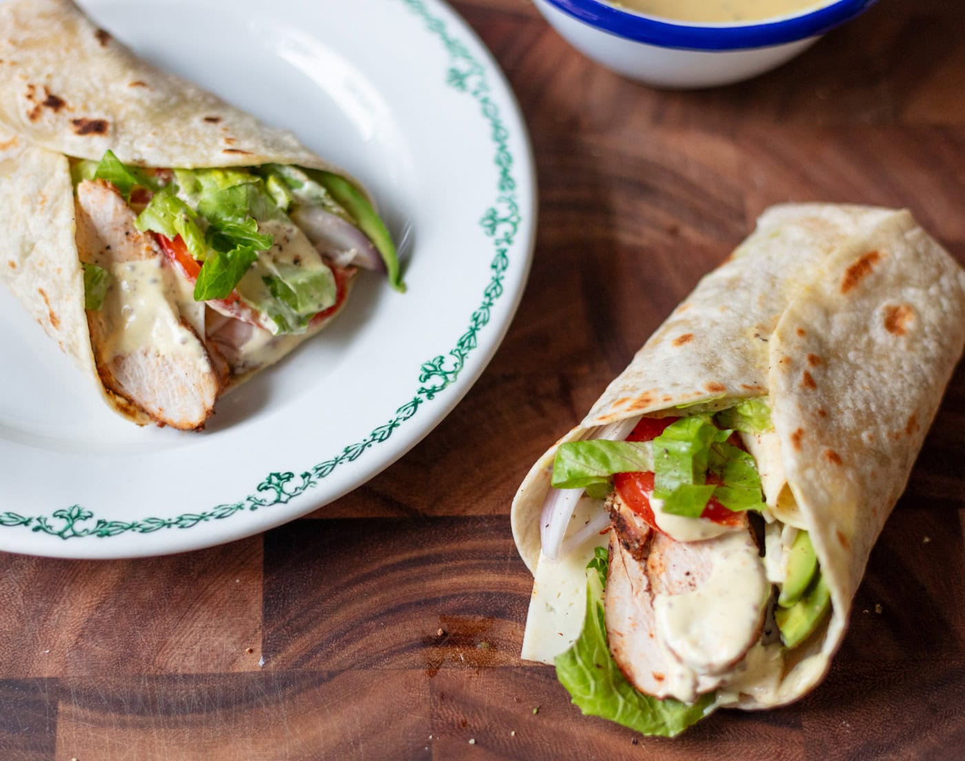 grilled chicken wraps with lettuce tomato avocado and hot honey mustard sauce in a tortilla