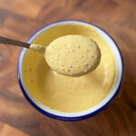 hot honey mustard sauce on a spoon showing creamy texture