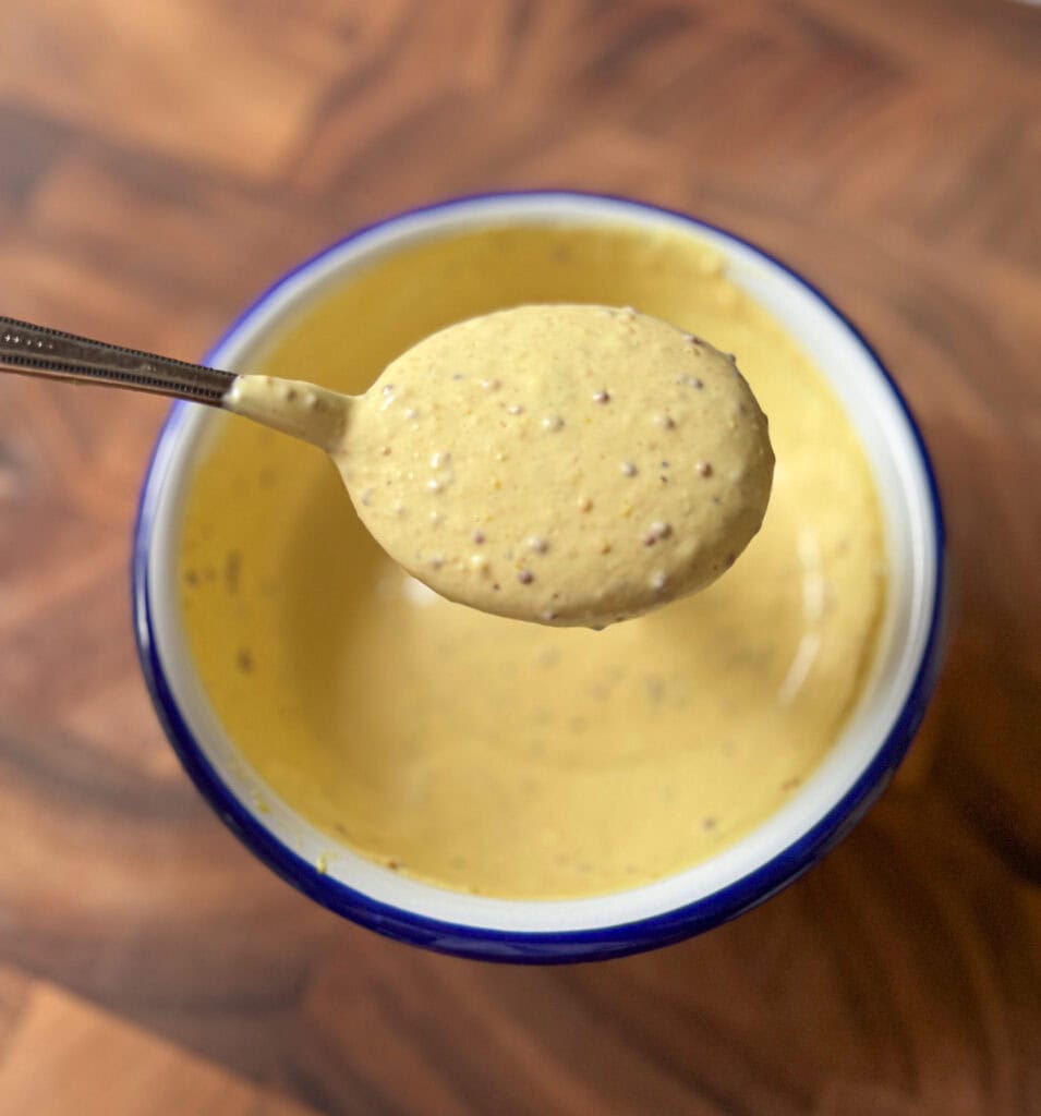 hot honey mustard sauce on a spoon showing creamy texture
