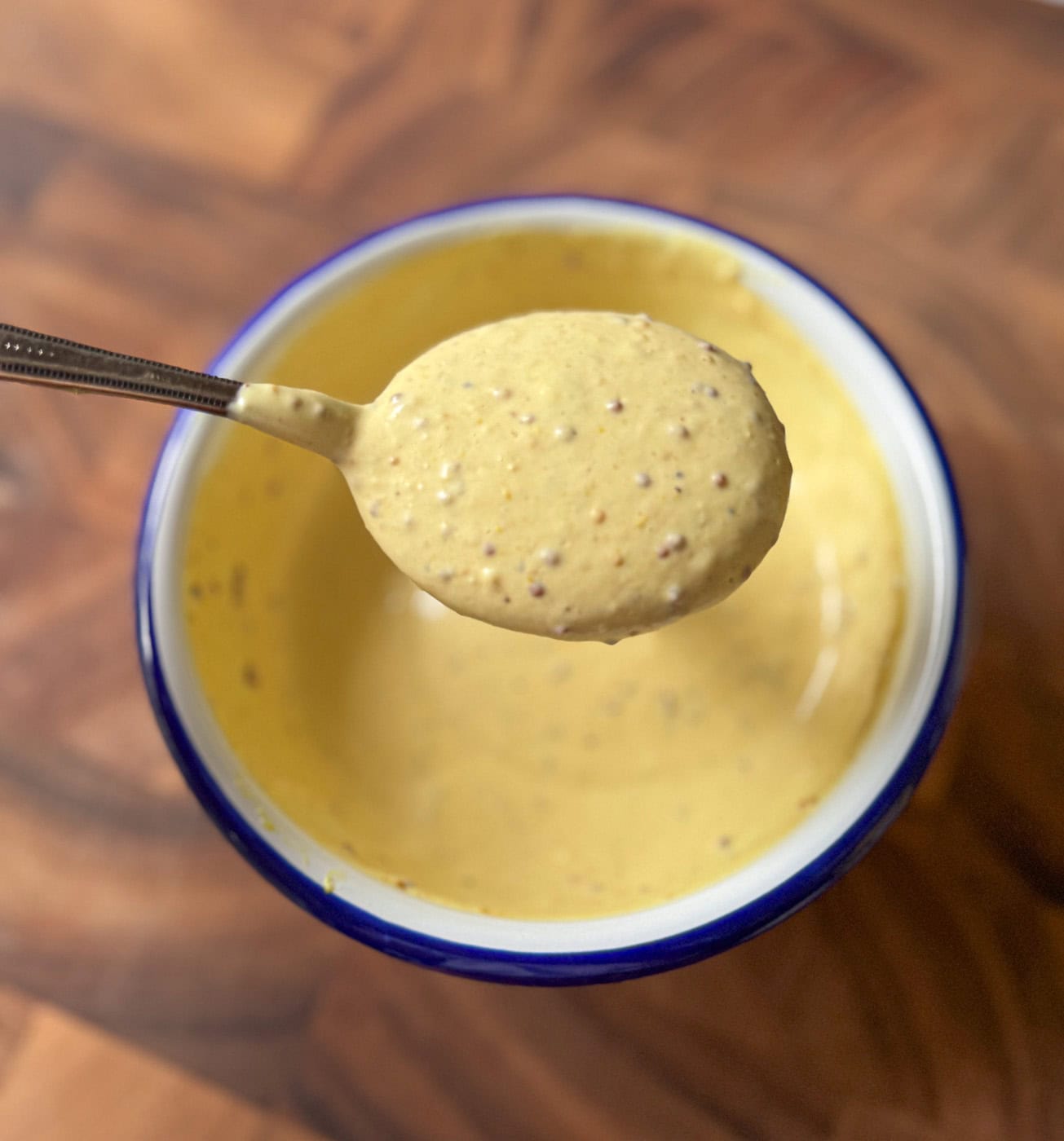 hot honey mustard sauce on a spoon showing creamy texture