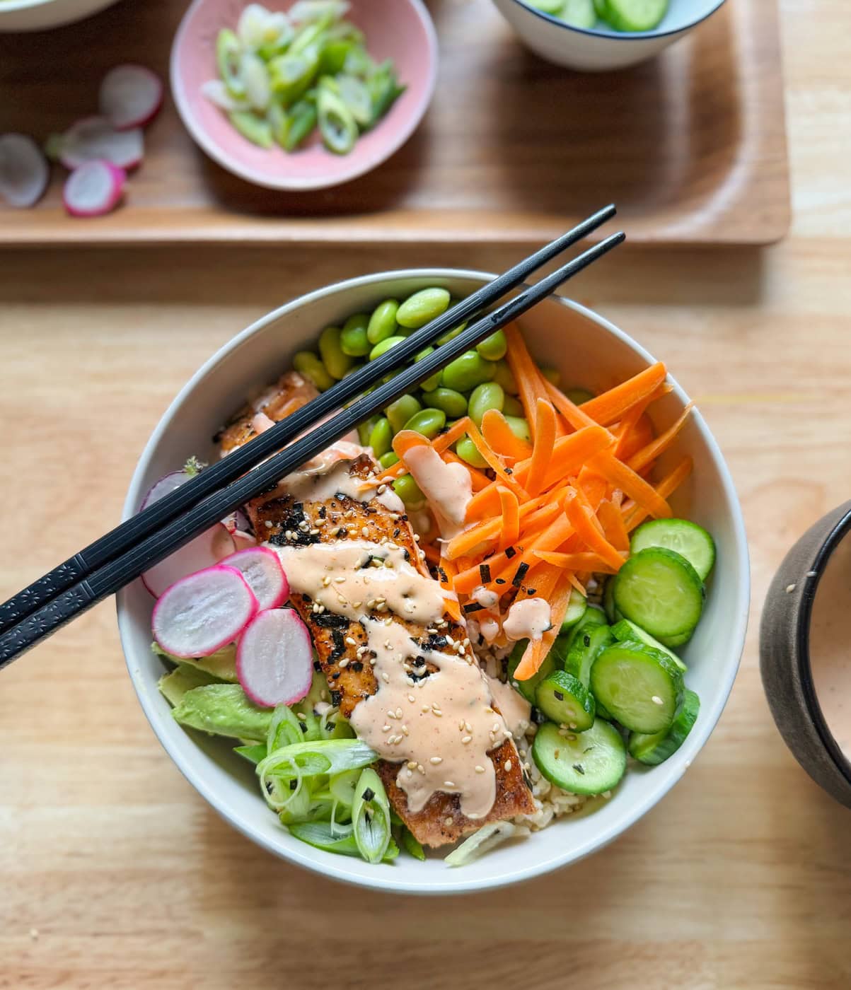 salmon rice bowl with spicy mayo avocado cucumber and edamame