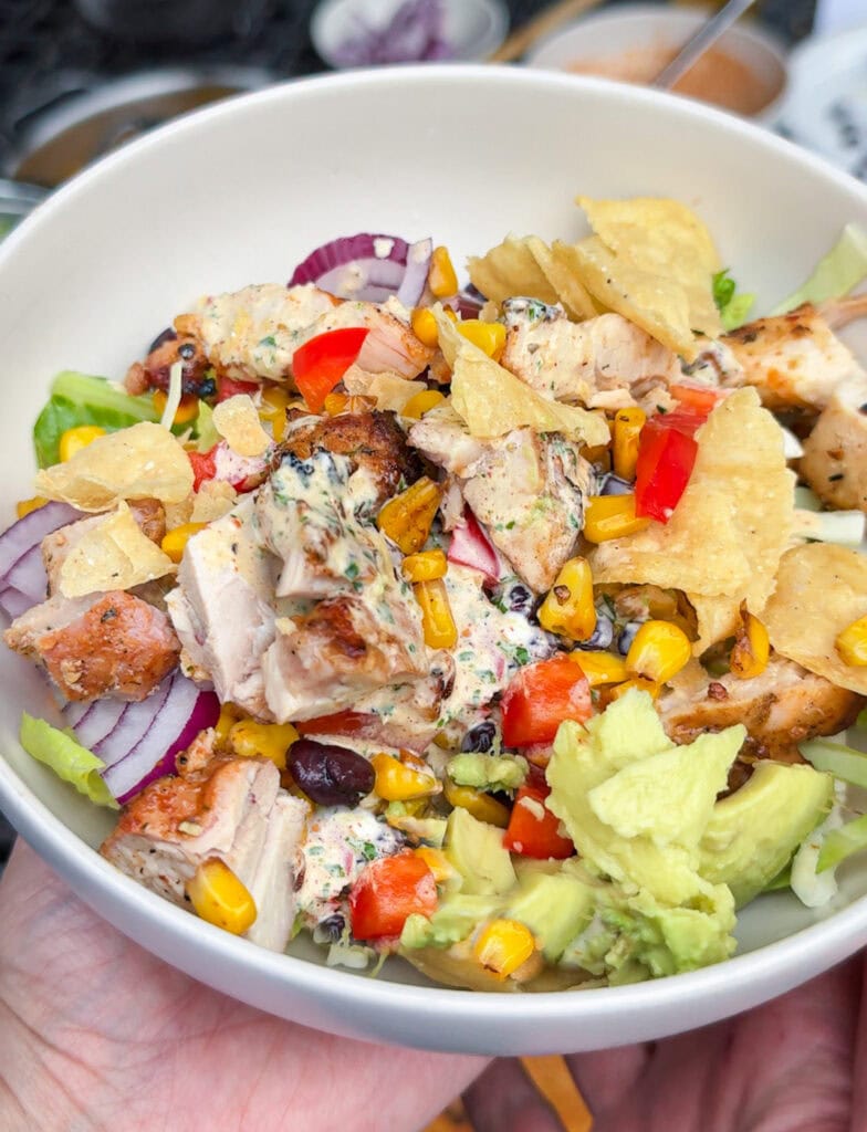 close up of southwest chicken salad with grilled chicken, corn, beans, avocado and creamy taco dressing