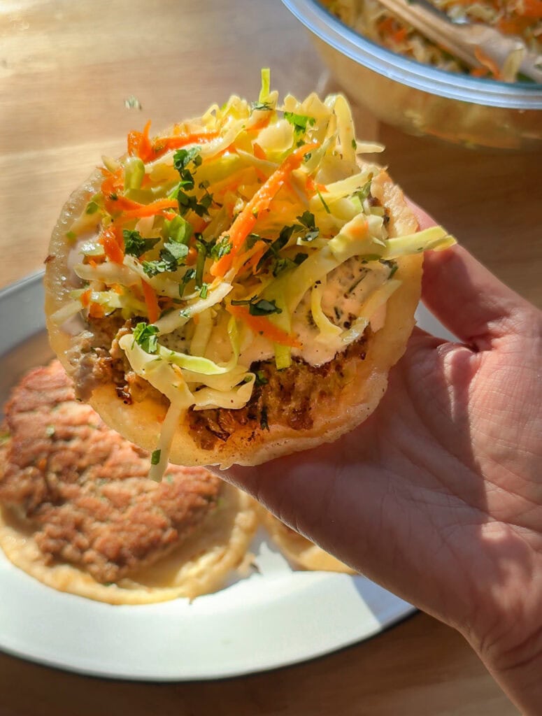 Crispy Asian smash taco topped with cabbage slaw, carrots, scallions, and spicy mayo.